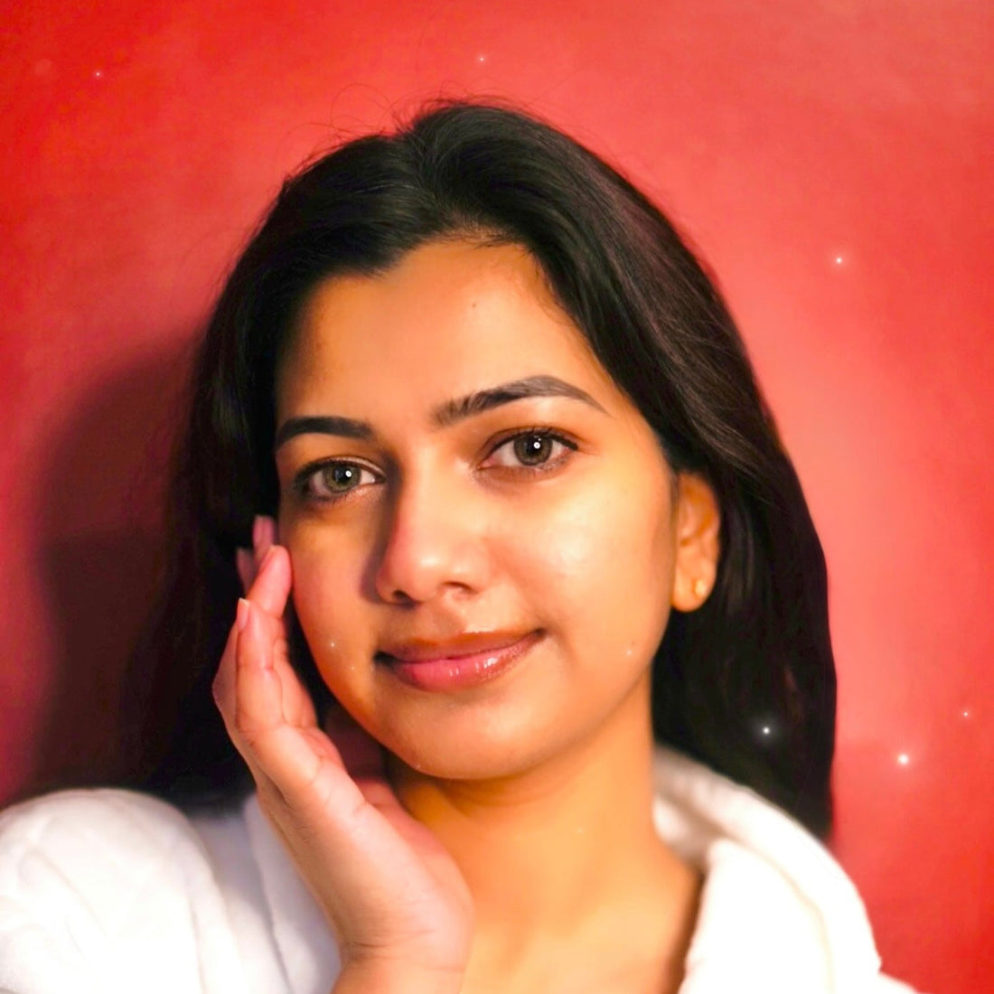Woman with smooth, glowing skin gently touching her face – natural skincare results with donkey milk moisturizer