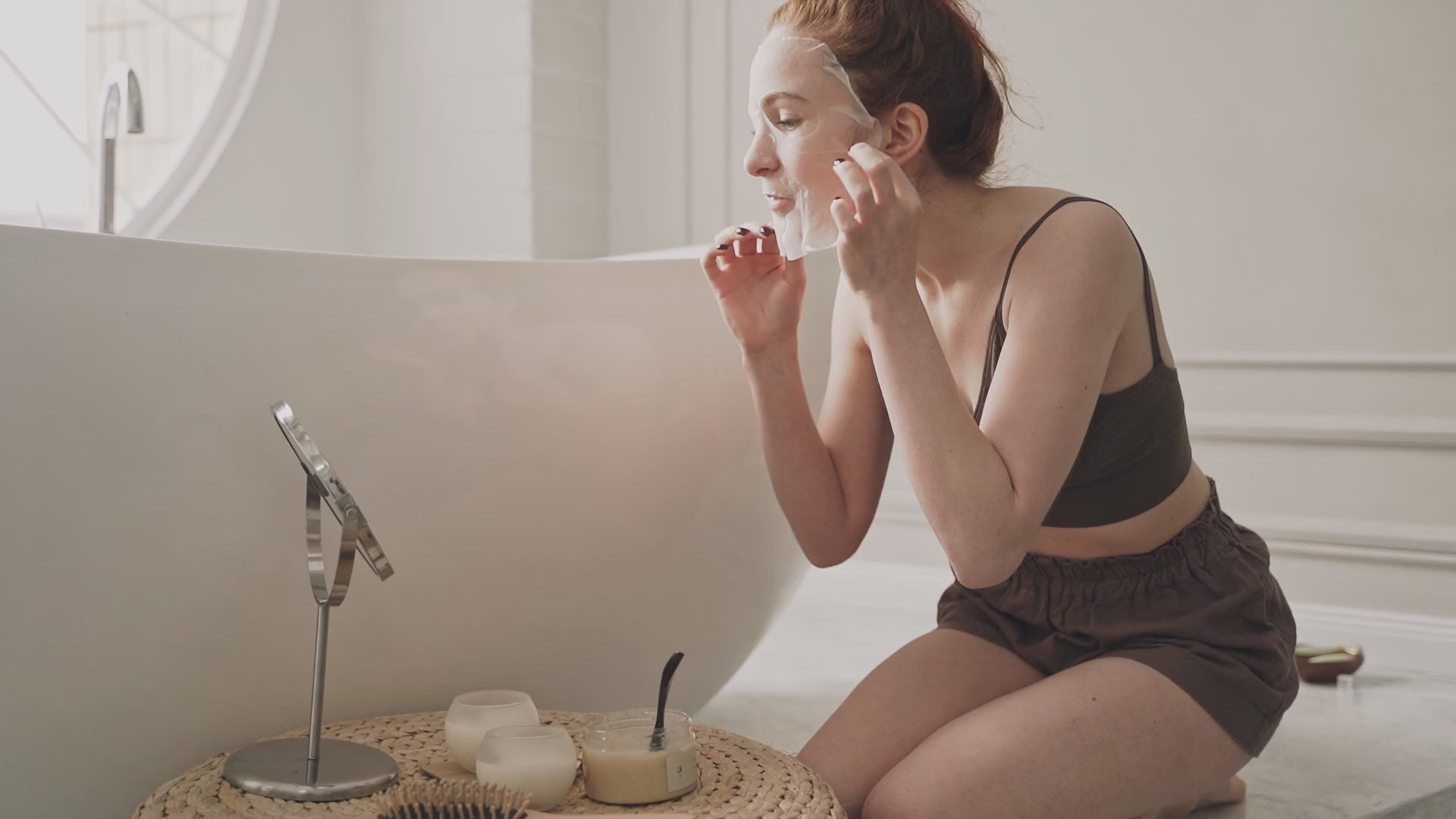 Load video: A visually engaging video showcasing Donk Milk Essentials face care products, including a face moisturizer, serum, and sheet masks, elegantly displayed on a natural wooden pedestal with soft lighting and green leaves in the background.